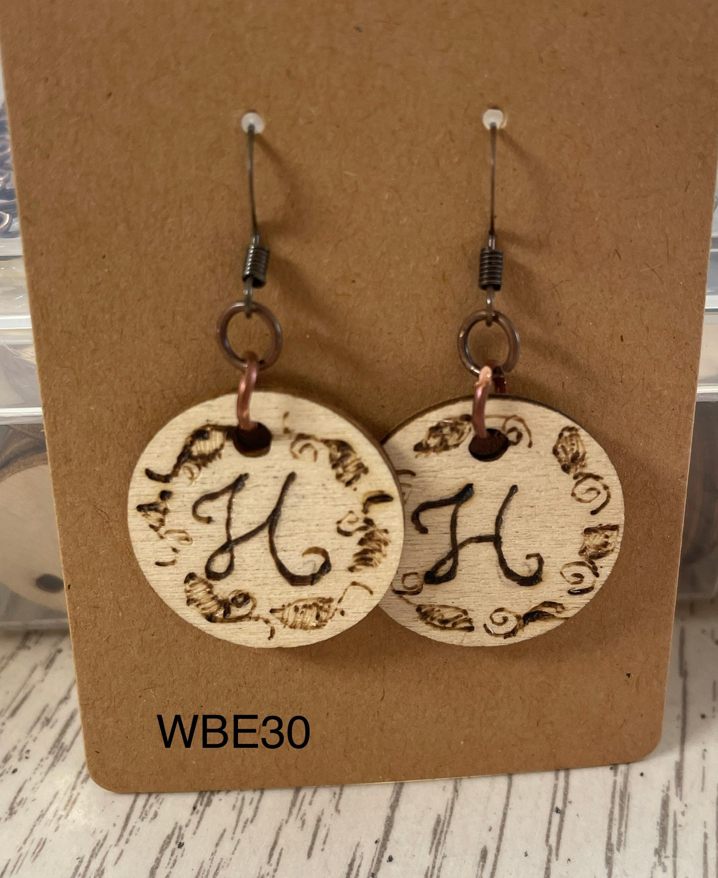 The letter H wood burned on wooden charms WBE30