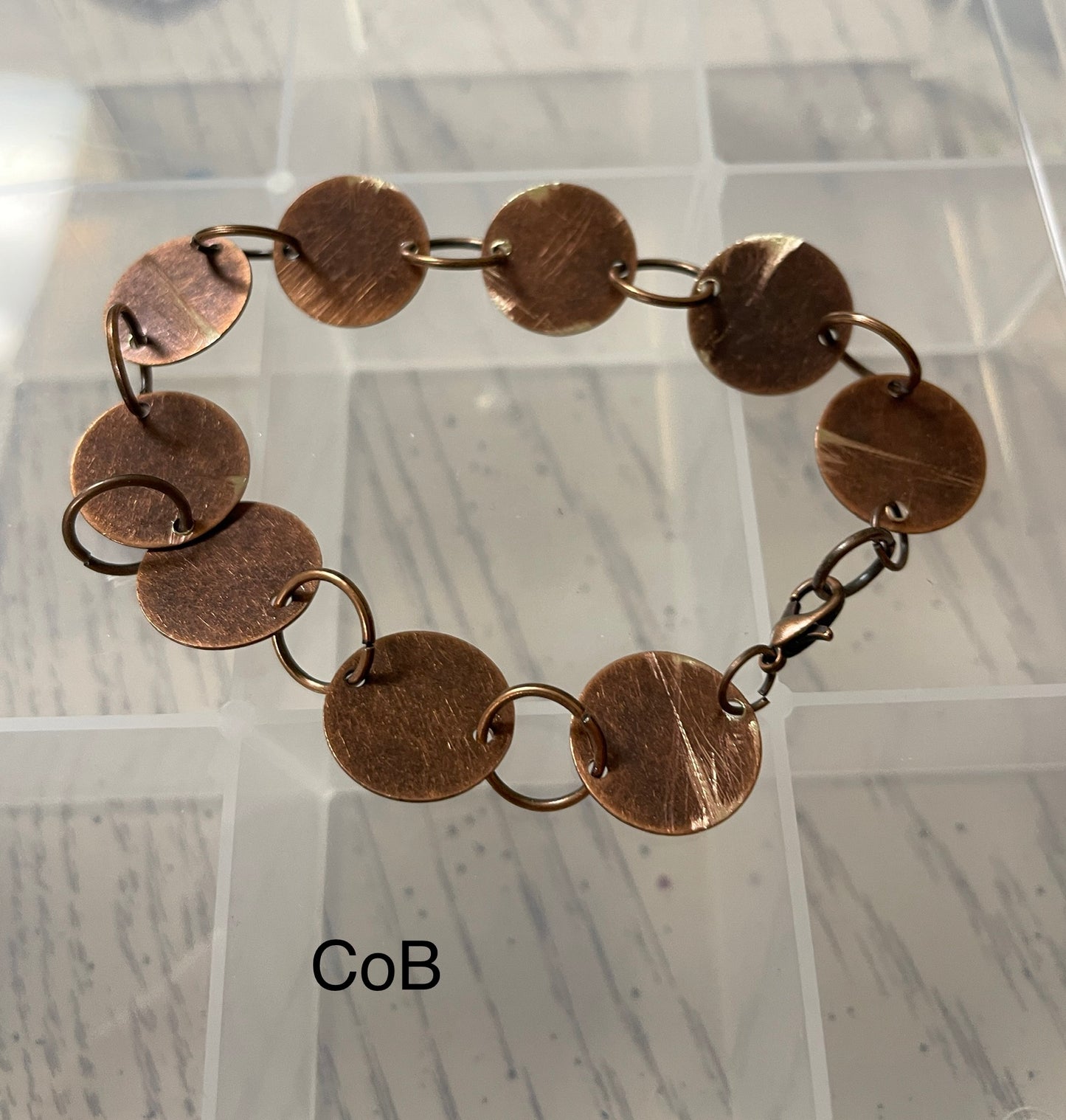 This copper bracelet is made from 1 inch round copper blanks and handmade round links. The bracelet is finished with a lobster clasp.